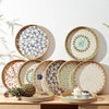A collection of handcrafted rattan serving trays featuring mother of pearl inlay in various shades of green, blue, and white.