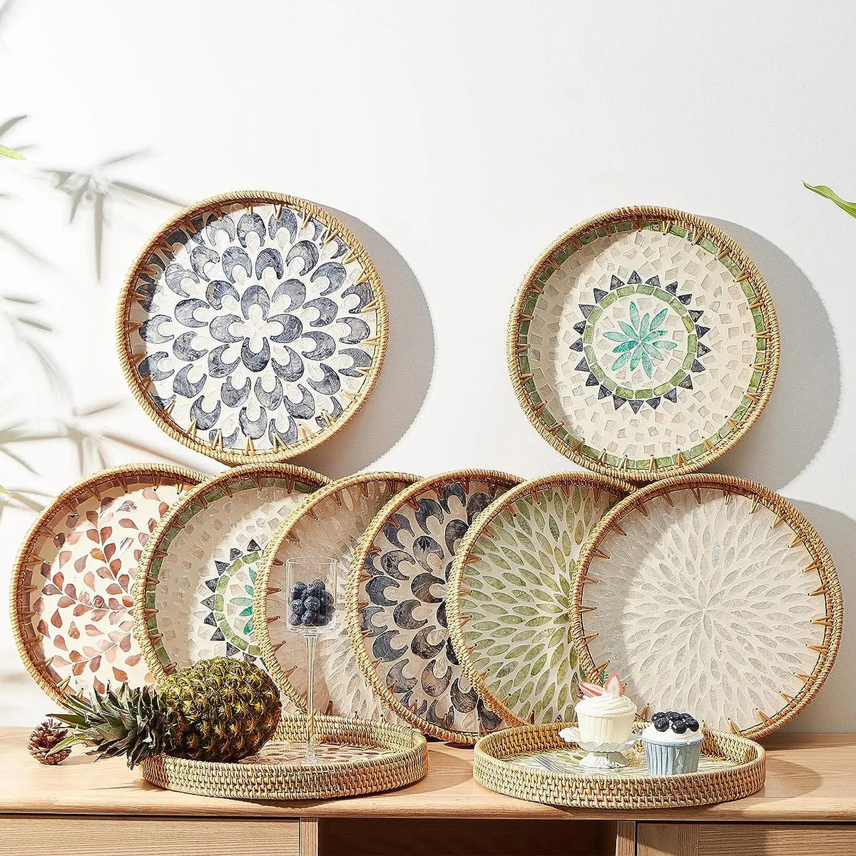 A collection of handcrafted rattan serving trays featuring mother of pearl inlay in various shades of green, blue, and white.