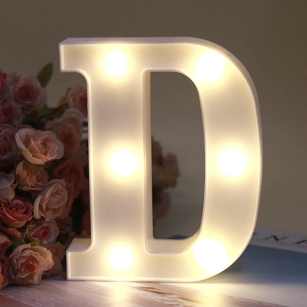 Lumière d'alphabet blanche LED en forme de lettre D, posée sur une surface en bois.