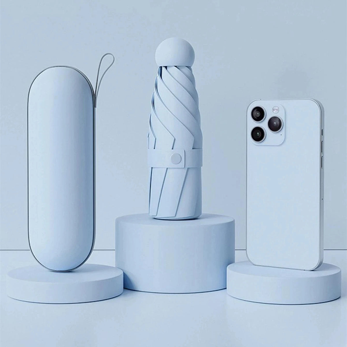 A light blue compact folding umbrella is displayed next to a smartphone on a white surface.