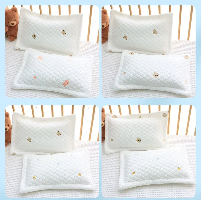 White quilted baby pillows with gold embroidered stars and hearts shown in various sizes