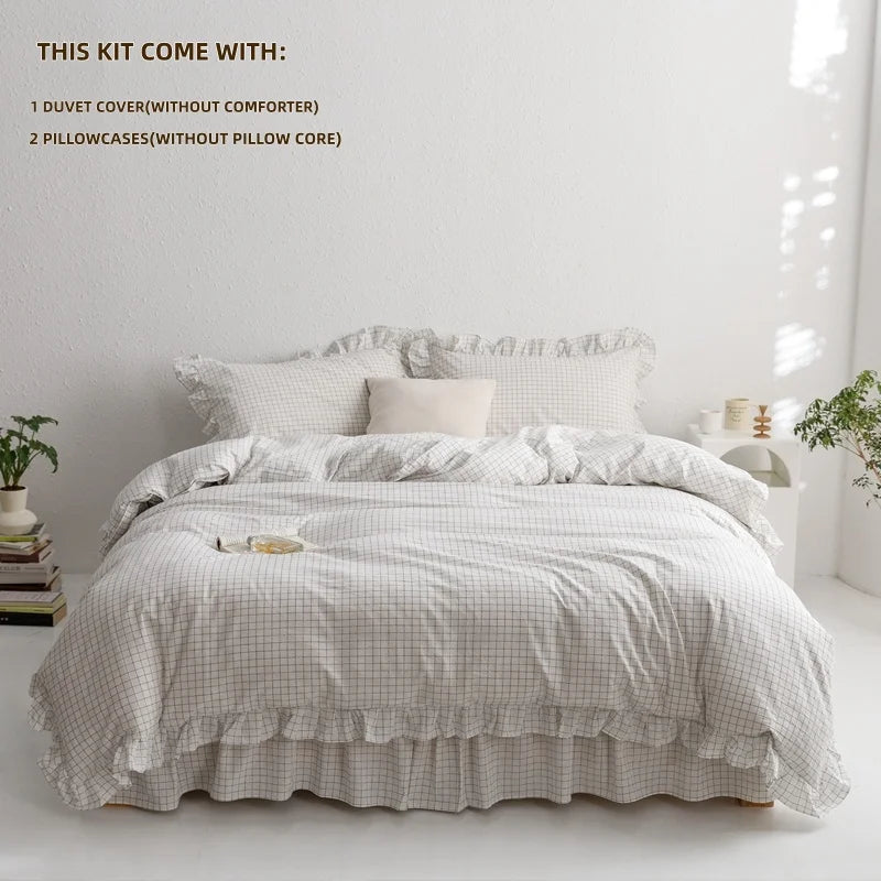 A plaid duvet cover set with two pillowcases displayed on a bed in a bright room.