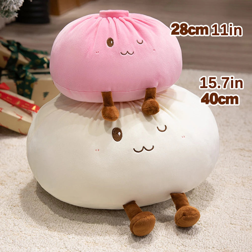 Un coussin en forme de dumpling rose pâle et blanc avec des pieds bruns, montré sur un fond clair.