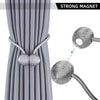 Gros plan d'un rideau de tissu gris avec des tirettes à boules magnétiques et un cordon amovible.