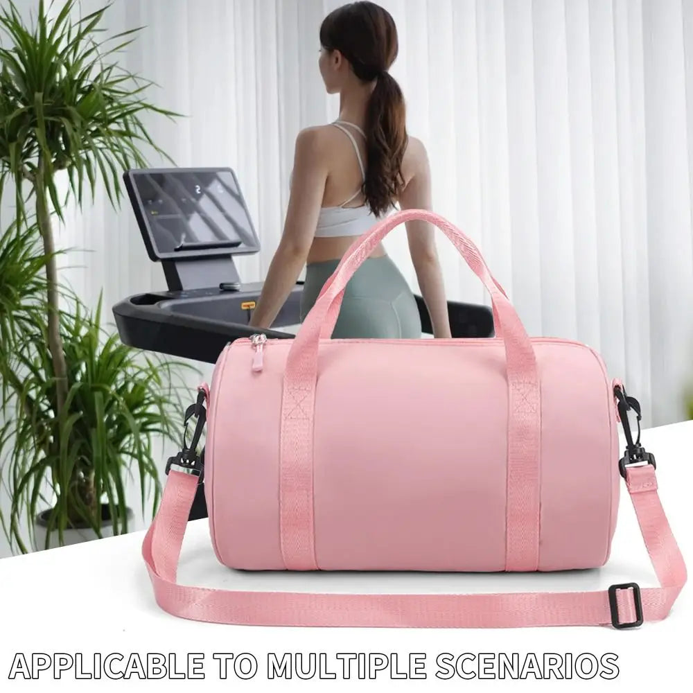 A pink compact nylon gym bag with an adjustable strap is shown on a white surface.