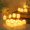 A collection of glowing white LED tea lights in glass holders arranged on a wooden surface with soft lighting.