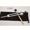 A set of tuning forks, including a mallet and various sized forks, is displayed on a black cloth background.