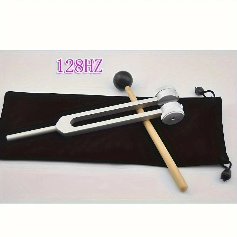 A set of tuning forks, including a mallet and various sized forks, is displayed on a black cloth background.