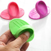 Three silicone finger covers in pink and green colors are shown, with one being held by a hand.