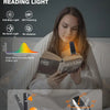 A woman reads a book using an eye protection book reading light with adjustable angles.