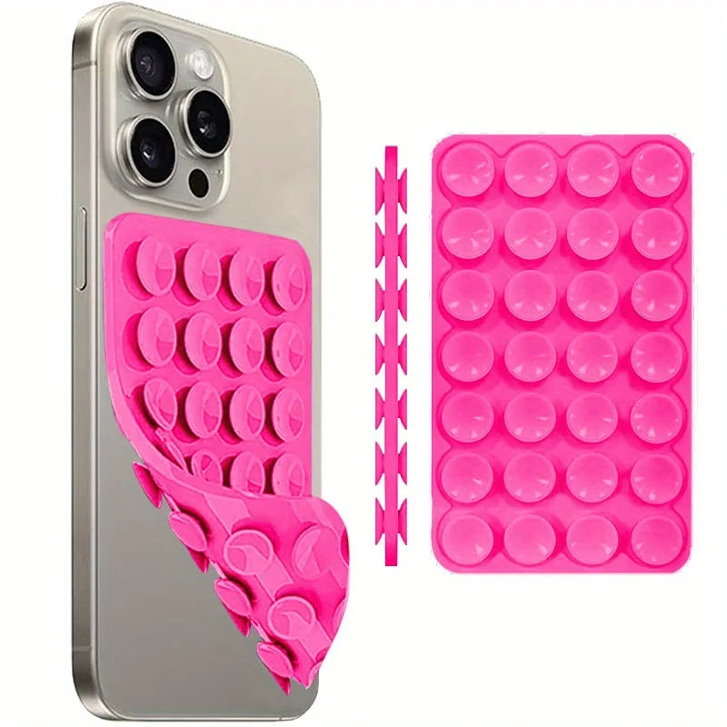 A silver smartphone is shown next to a pink silicone suction cup phone mount and a pink silicone grip.
