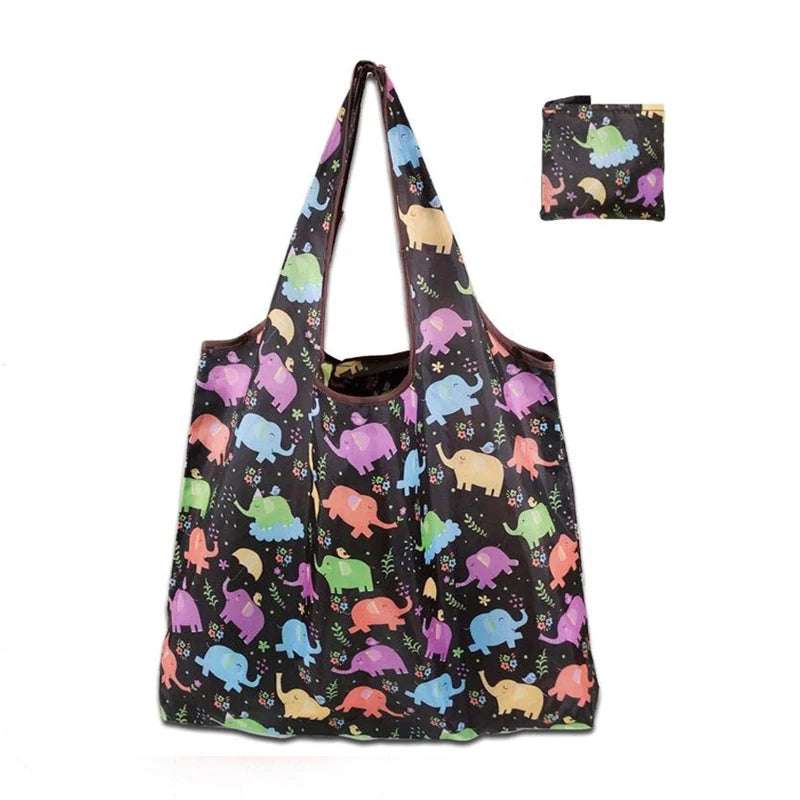 A reusable shopping tote bag featuring a dark background with colorful animal patterns and an attached small carry pouch.