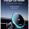 A black magnetic wireless car charger holder with blue RGB lights mounted on a car grille.