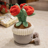 A cute artificial flower plush doll with orange petals and green leaves, set in a light gray pot.