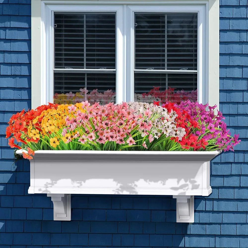 Una caja de ventana llena de ramos artificiales de narcisos de colores, con flores rosas, amarillas y rojas