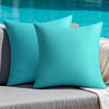Two teal linen-textured cushion covers resting on a gray outdoor sofa.