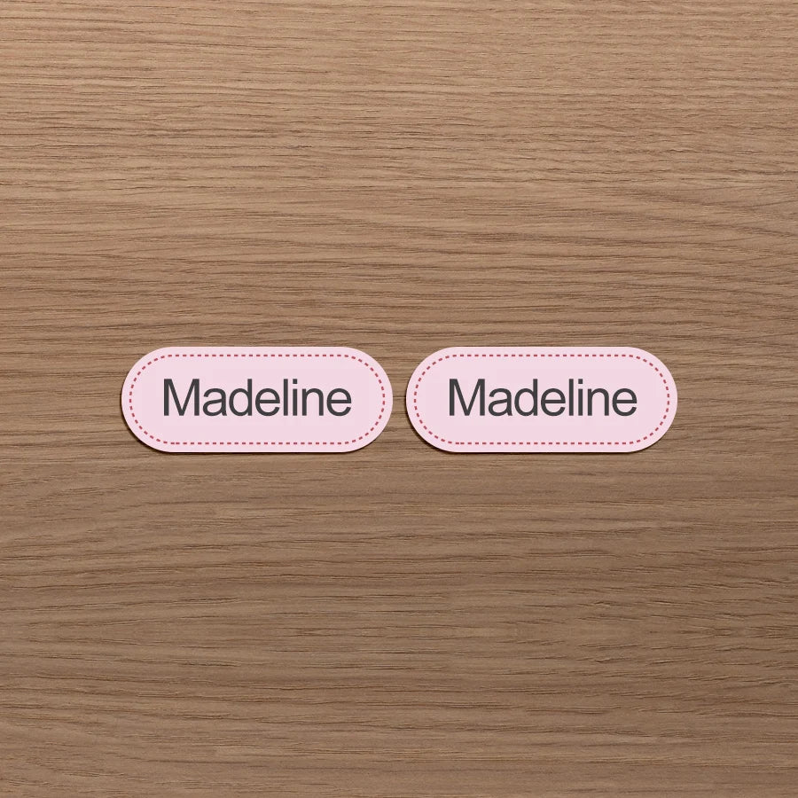 Dos etiquetas ovaladas rosas con el nombre Madeline impreso