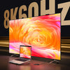 A laptop displaying a vibrant orange and pink swirl pattern is positioned in front of an 8K monitor.