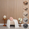 A display of wood grain peel-and-stick wall tiles in various shades of brown and gray on a beige wall.