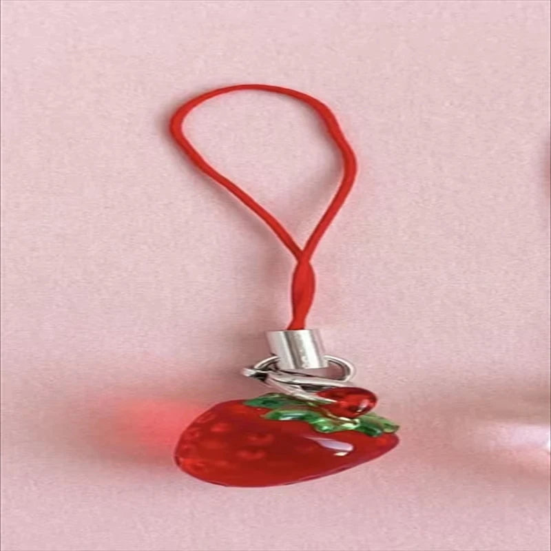Red strawberry resin phone charm keychain with a red cord