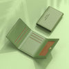 A light green leather card holder wallet with multiple slots shown open and closed on a pale green surface.