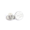 A silver metal button with the word Jeans Wear engraved on it.