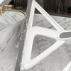 A white silicone squeegee broom is shown cleaning a marble countertop with a gold-toned faucet.