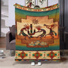 A colorful ethnic print flannel throw blanket featuring stylized desert animals and geometric patterns.
