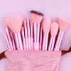 Eine Sammlung von rosa und nude veganen Luxus-Make-up-Pinseln auf einem rosa Handtuch.