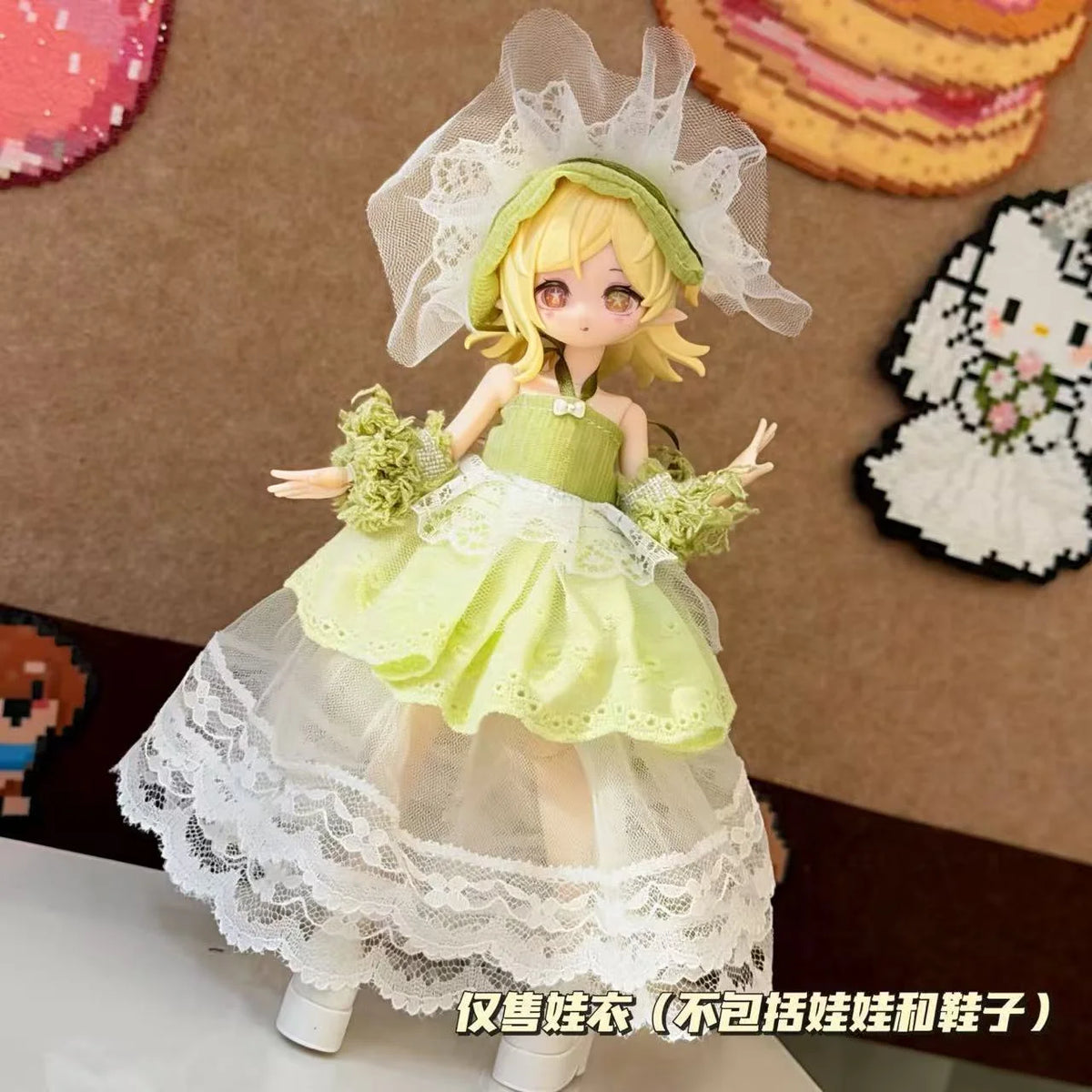 A female doll dressed in a sweet maid outfit featuring a light green dress, white lace, and a sheer veil.