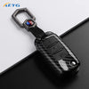 A carbon fiber car key cover for VW and Skoda models with a metal key ring.