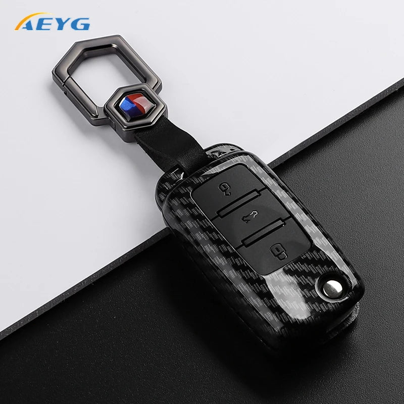 A carbon fiber car key cover for VW and Skoda models with a metal key ring.