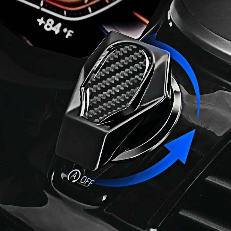 A close-up view of a black metal button cover and engine switch decal for a car interior.