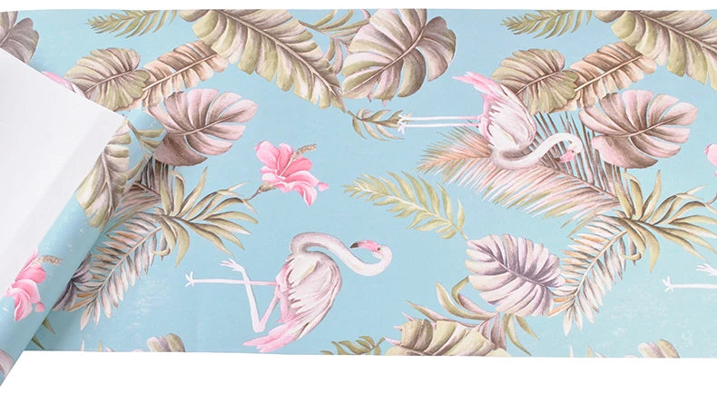 Light blue wallpaper featuring a dense floral pattern of pink and green tropical leaves and flamingos.