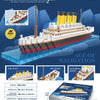 A model kit of a cruise ship built from small plastic blocks, showing various parts and packaging details.