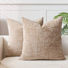 A beige handwoven chenille texture cushion cover resting on a light-colored sofa.