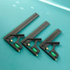 A black multifunctional carpenter square with an angle level and protractor laid on a teal surface.