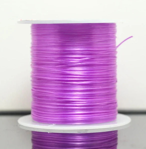 A spool of purple elastic cord used for beading and jewelry making.