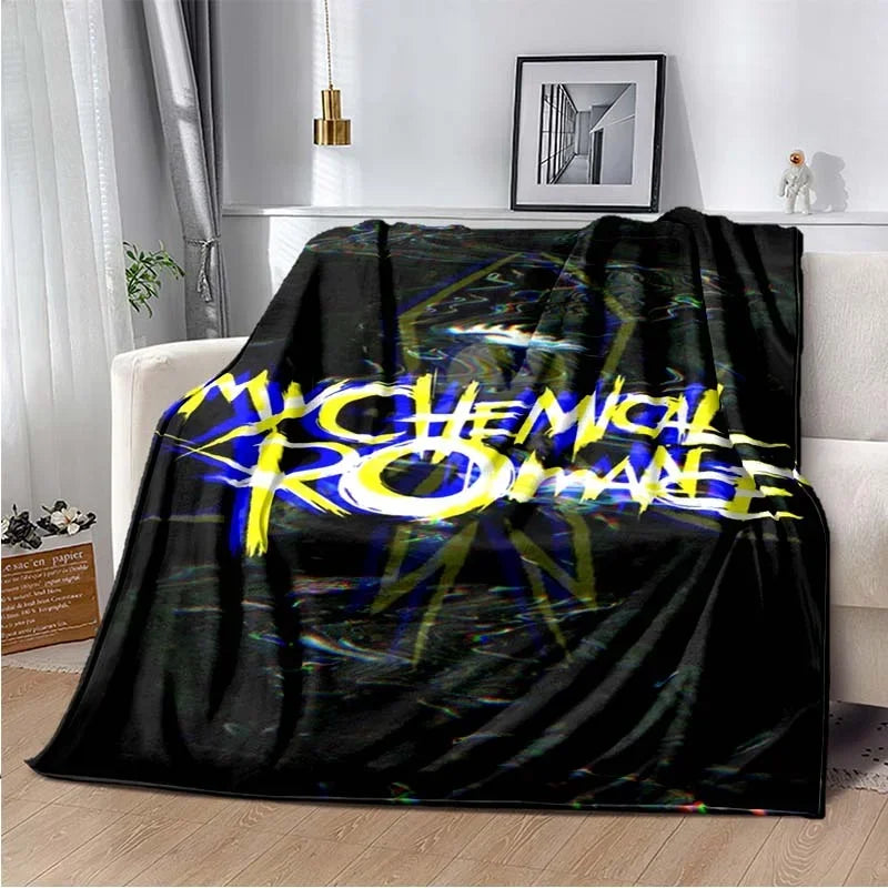 A black fleece throw blanket featuring the My Chemical Romance band logo in yellow and white text with a dark, abstract backg