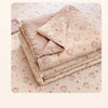 A stack of light pink quilt fabric featuring a cartoon pattern of pink animals on a white background.