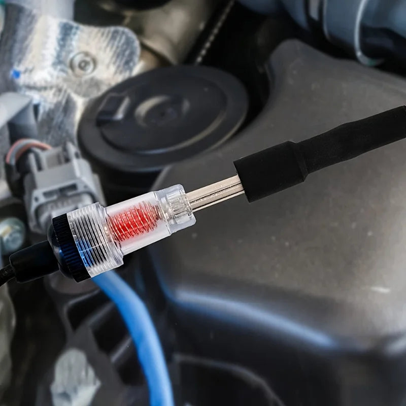 An automotive spark plug ignition tester with a diagnostic gauge and connector cable is shown in a close-up view.