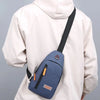 A beige hooded jacket is shown wearing a navy blue Oxford canvas crossbody chest bag with multiple pockets.