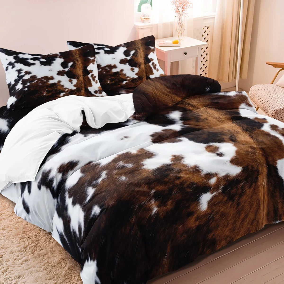 A brown and white cow print duvet cover set with matching pillowcases displayed on a bed.