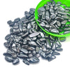 A pile of tumbled natural crystal stone chips in various shades of gray and black, with a green bowl nearby.