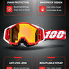 A pair of red and orange off-road motorcycle goggles with clear lenses shown against a dark background.