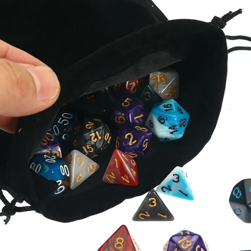 A hand holds an open black storage bag filled with multicolor polyhedral dice.