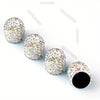A collection of colorful, crystal-cut tire valve caps scattered on a white background.