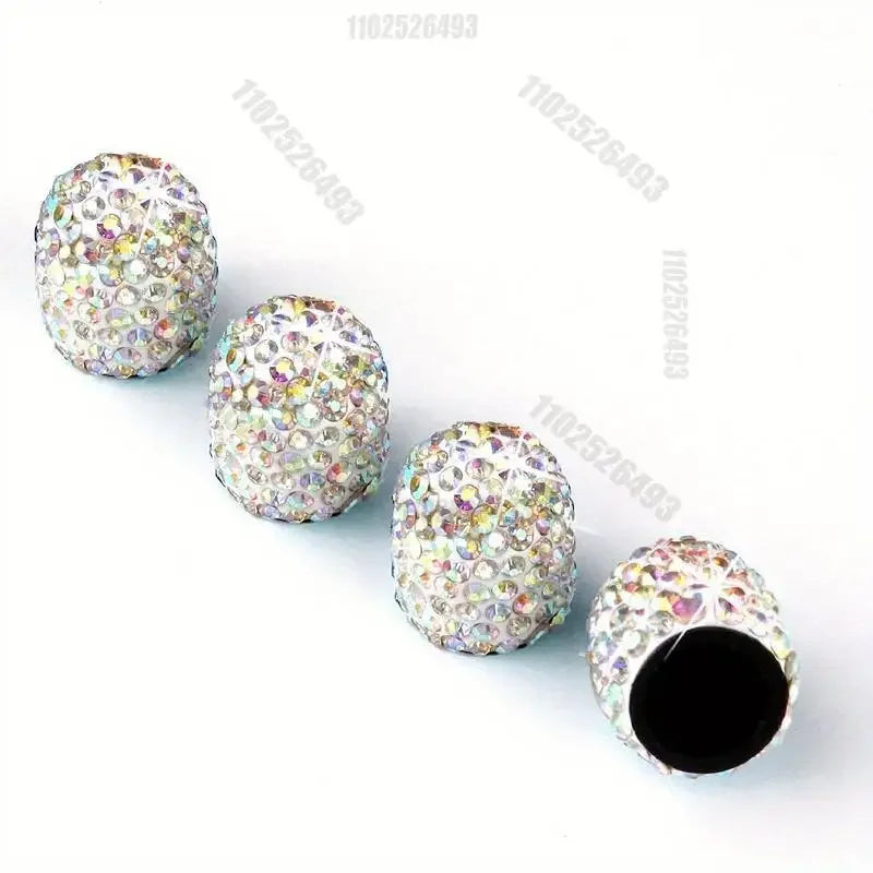 A collection of colorful, crystal-cut tire valve caps scattered on a white background.
