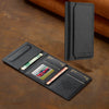 A black magnetic wallet phone case with card slots and a kickstand resting on a brown surface.