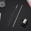 A set of long, thin stainless steel straws with measuring marks displayed on a dark surface.